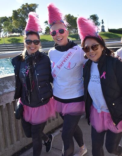 Three females dressed in pink during a breast cancer walk.