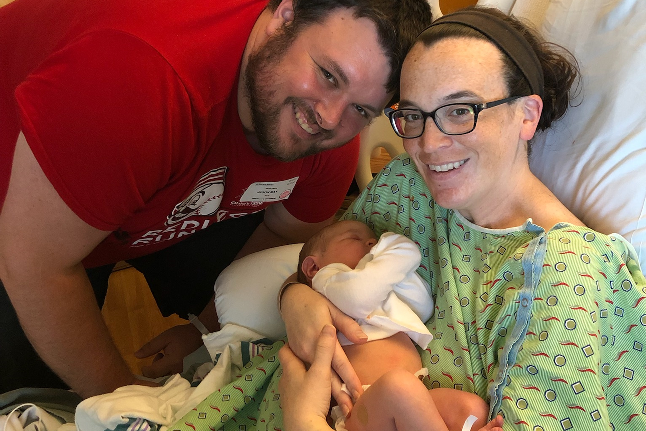 Smiling mom and dad with newborn infant