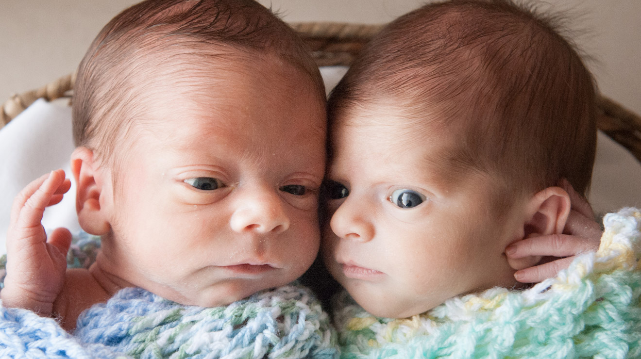 Boy-girl twins laying side-by-side.