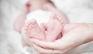 Mom holding baby's feet in her hand.