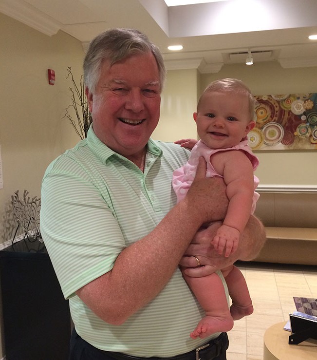 Happy baby girl being held by the doctor who helped her parents conceive her.