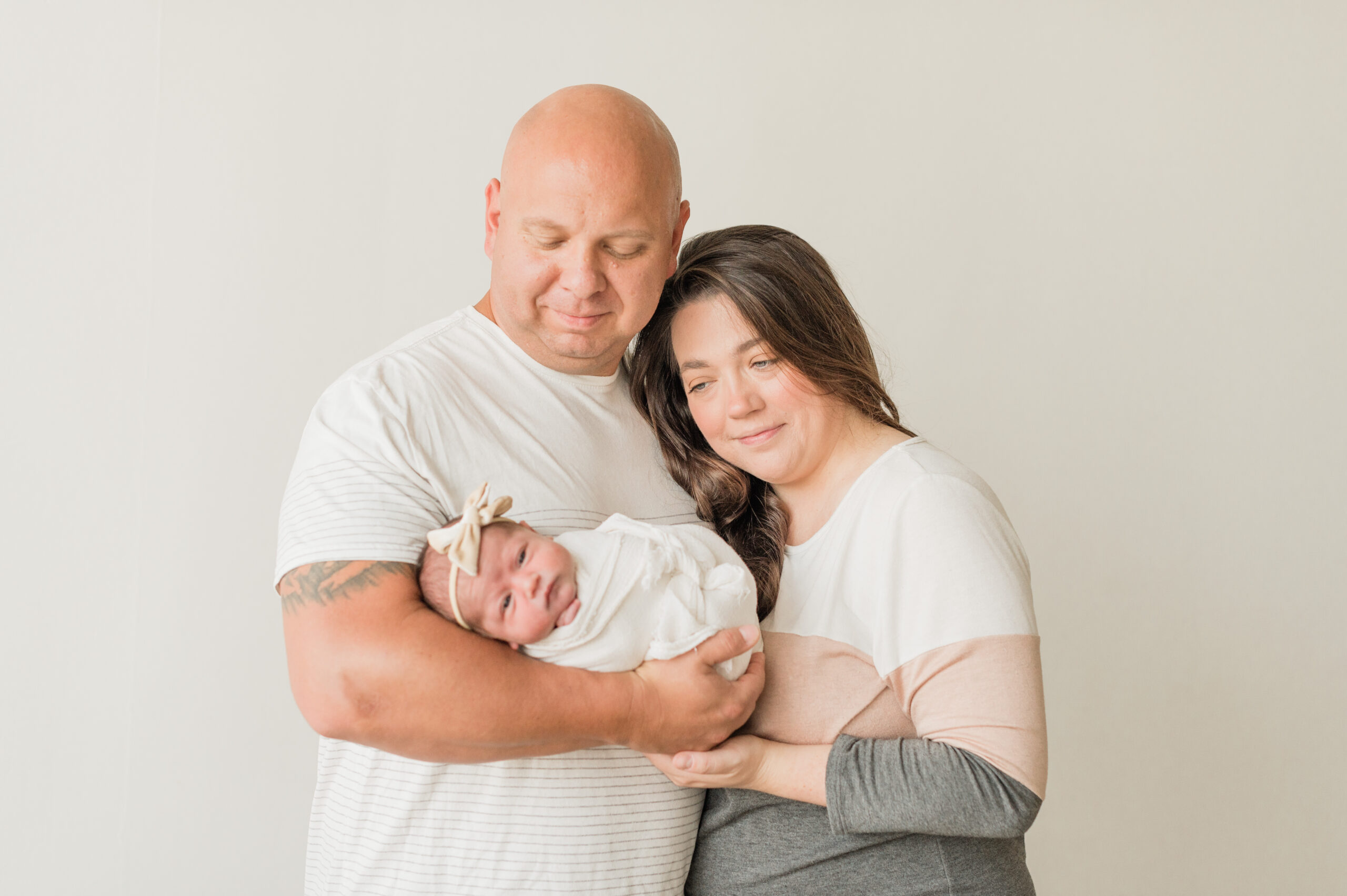 Smiling mom and dad holding newborn baby girl.