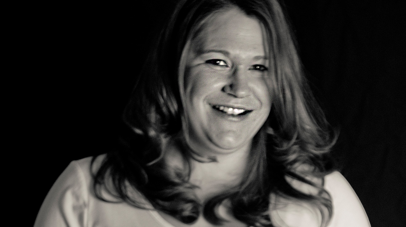 Black and white photo of a smiling mom.